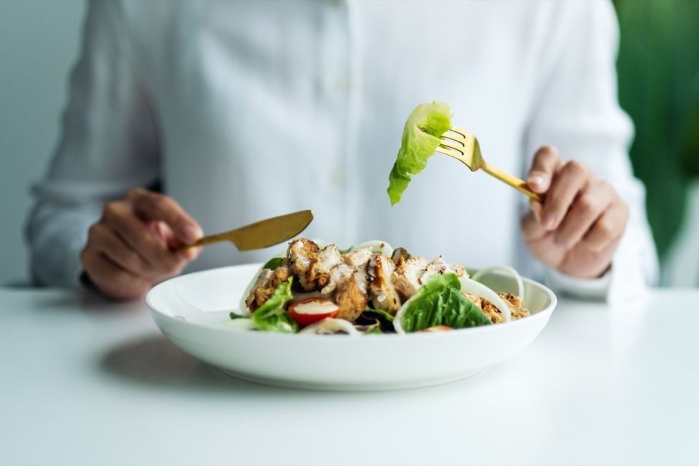 woman eating salad with chicken