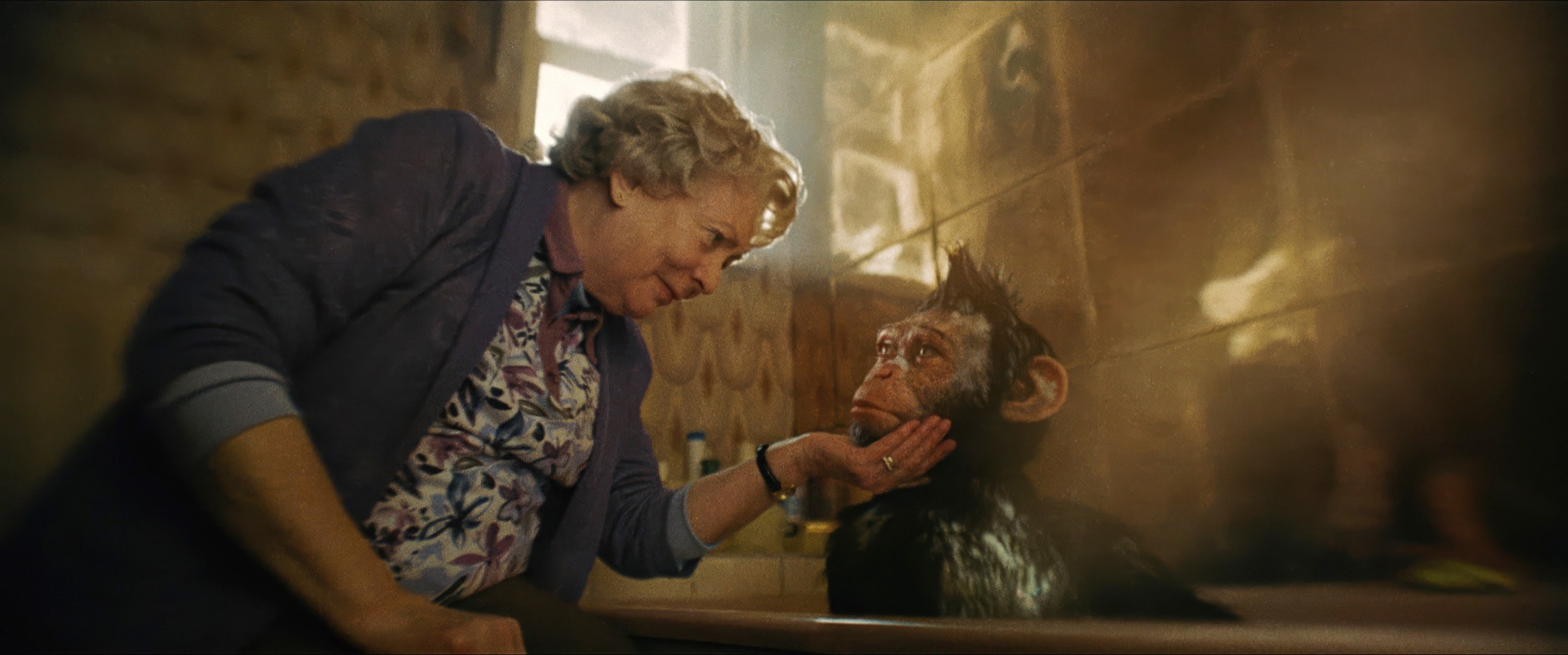 In Better Man, Alison Steadman holds the chin of a CG monkey Robbie Williams who is taking a bath, as they look in each other’s eyes