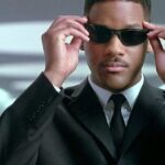 will smith wears a suit and holds his shades in men in black and will possibly star in a matrix movie