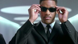 will smith wears a suit and holds his shades in men in black and will possibly star in a matrix movie