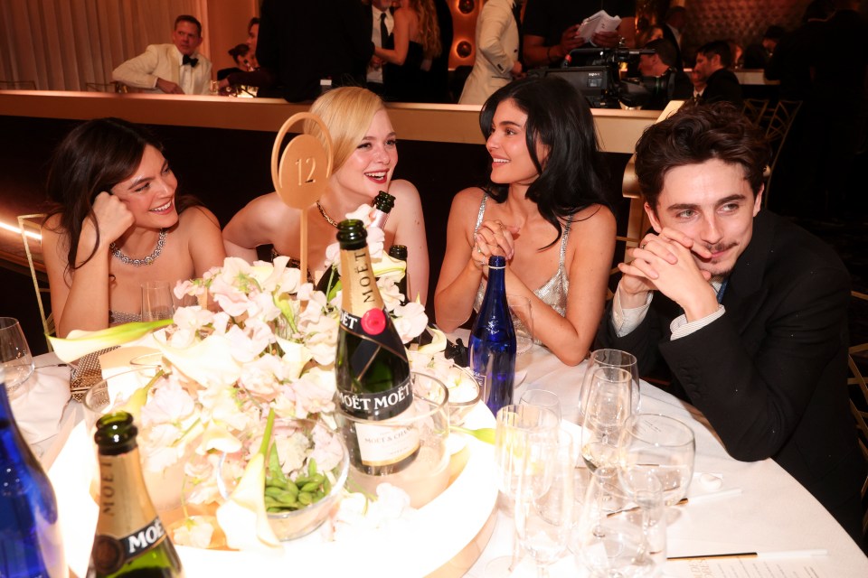 L-R: Monica Barbaro, Dakota Fanning, Elle Fanning, Kylie Jenner and Timothée Chalamet at their Golden Globes table