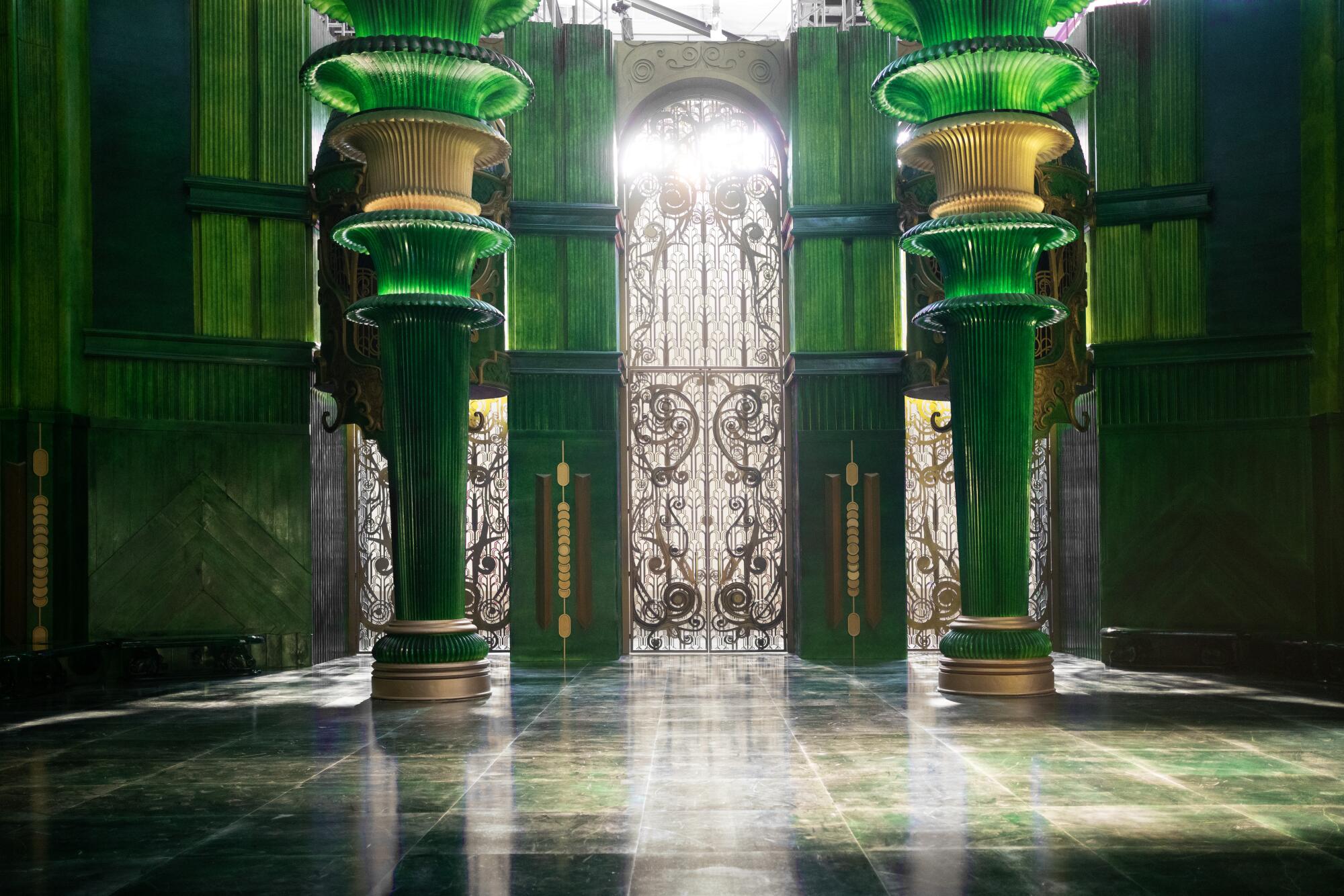 Bright green columns and walls sit behind an intricate gate.