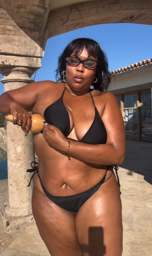 Lizzo flaunts her curves in black bikini as she uses a guasha on her body