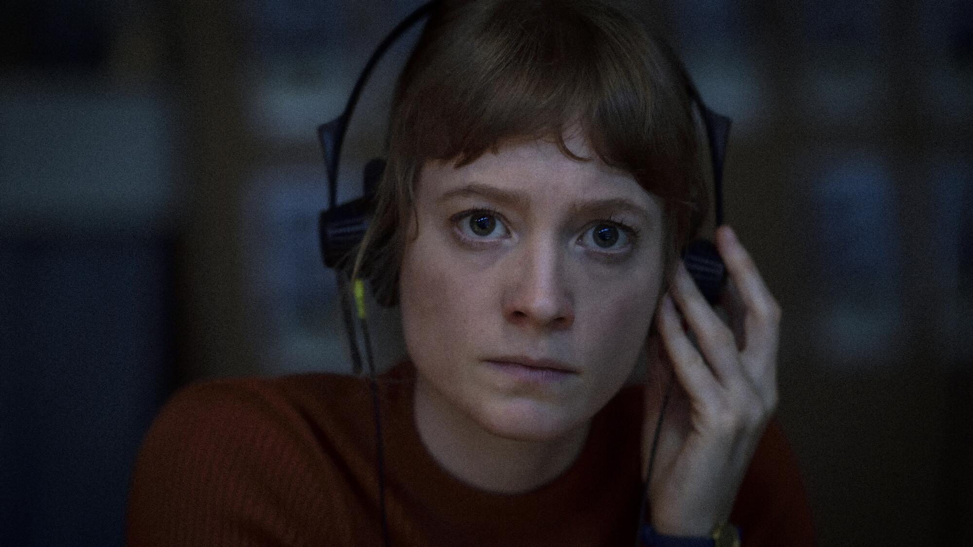 An intense looking woman wears headphones in "September 5."