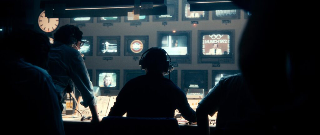 A team of broadcasts, in shadow, face a bank of monitors in "September 5."