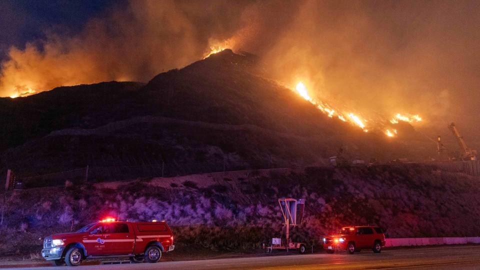 Flames are seen on the hill-side between Malibu and Pacific Palisades in Los Angeles