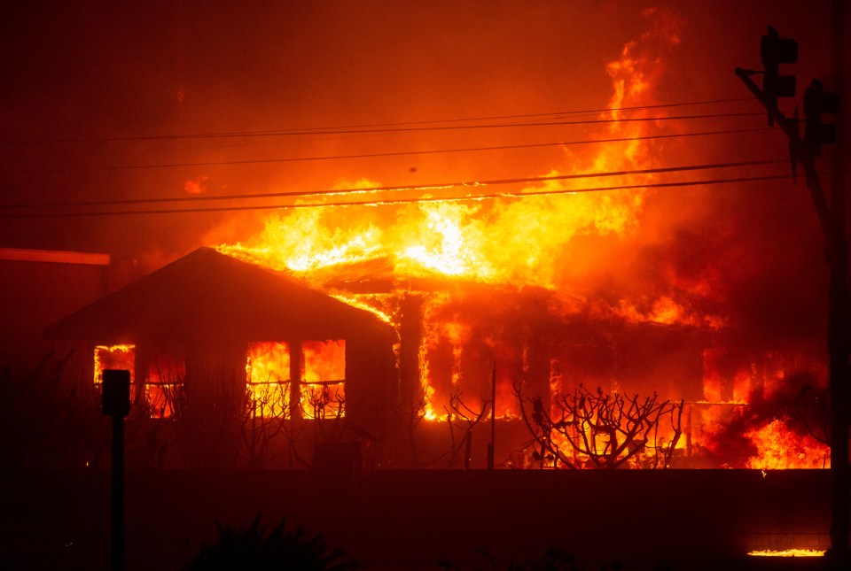 Fire engulfs a structure as the Palisades Fire burns during a windstorm