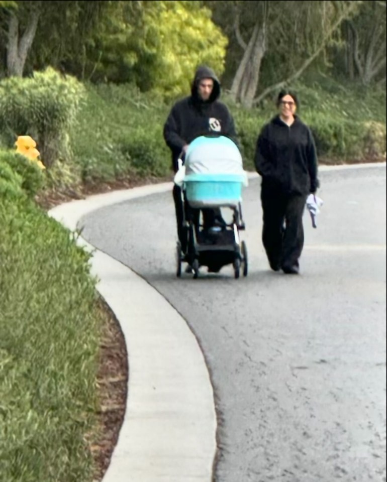 Kourtney Kardashian and Travis Barker walk outside their Calabasas home