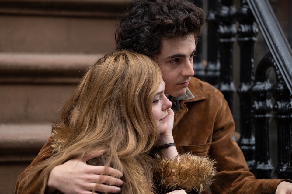 Timothée Chalamet and a woman embracing on a stoop.