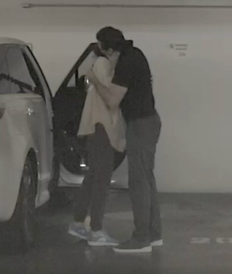 Hugh Jackman and Sutton Foster kissing near a car.