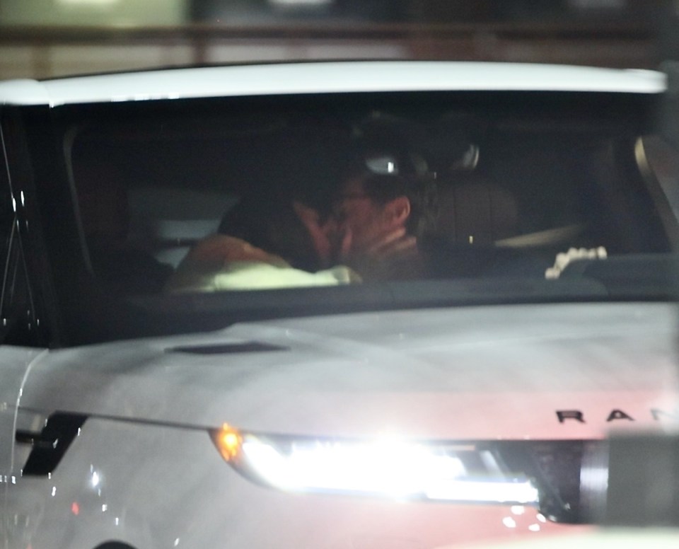 Hugh Jackman and Sutton Foster kissing in a car.