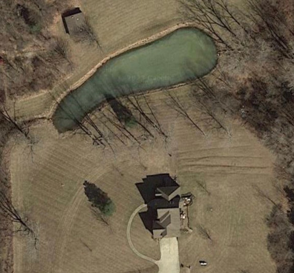 Aerial view of a house and pond on a property.