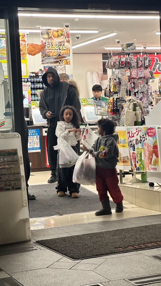 Kanye West leaving a 7-Eleven with his three children.