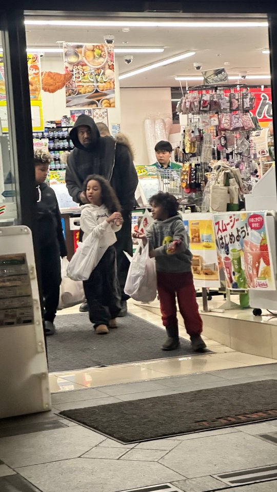 Kanye West leaving a 7-Eleven with his three children.