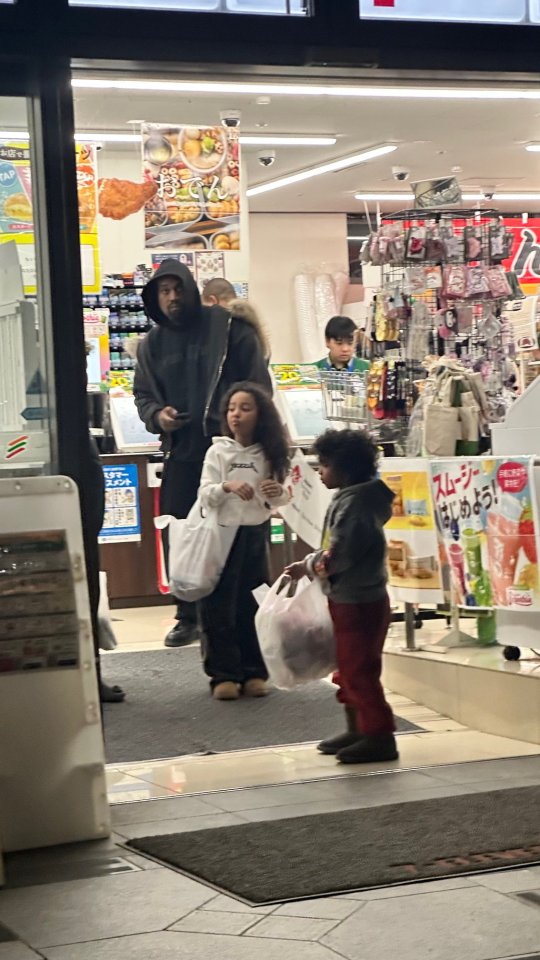 Kanye West leaving a 7-Eleven with his three children.