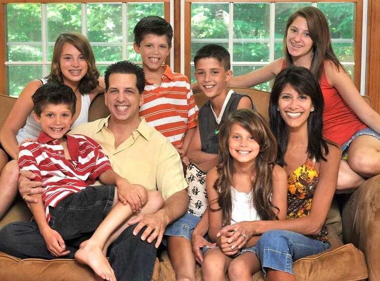 Family portrait of a large family sitting on a couch.