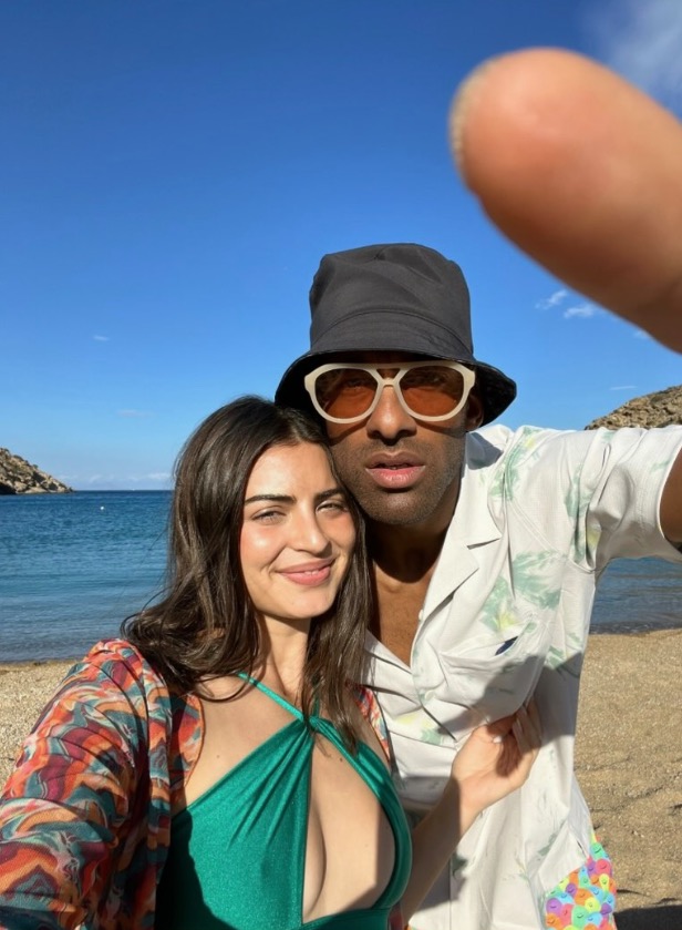 Couple posing for a selfie on a beach.