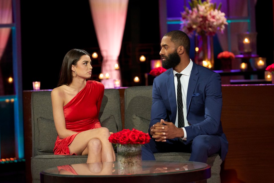 Matt James and a woman in a red dress sit on a couch during the After the Final Rose special.