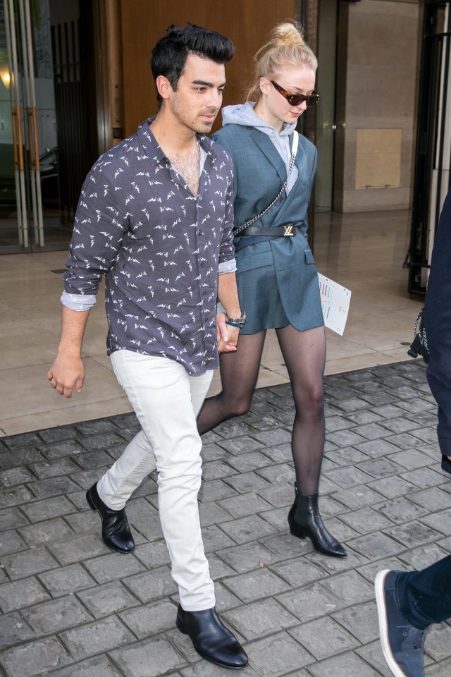 Joe Jonas and Sophie Turner holding hands while walking.