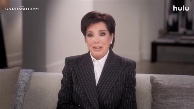 Kris Jenner in a pinstripe suit, appearing emotional in a scene from The Kardashians on Hulu.