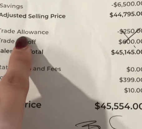 Close-up of a car sales receipt showing a final price of $45,554.00.