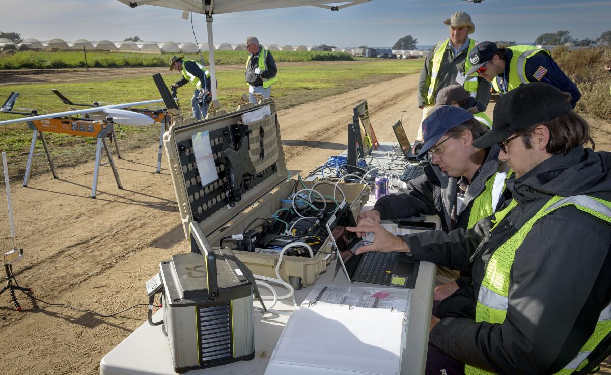 People gather at an airfield near a small aircraft.