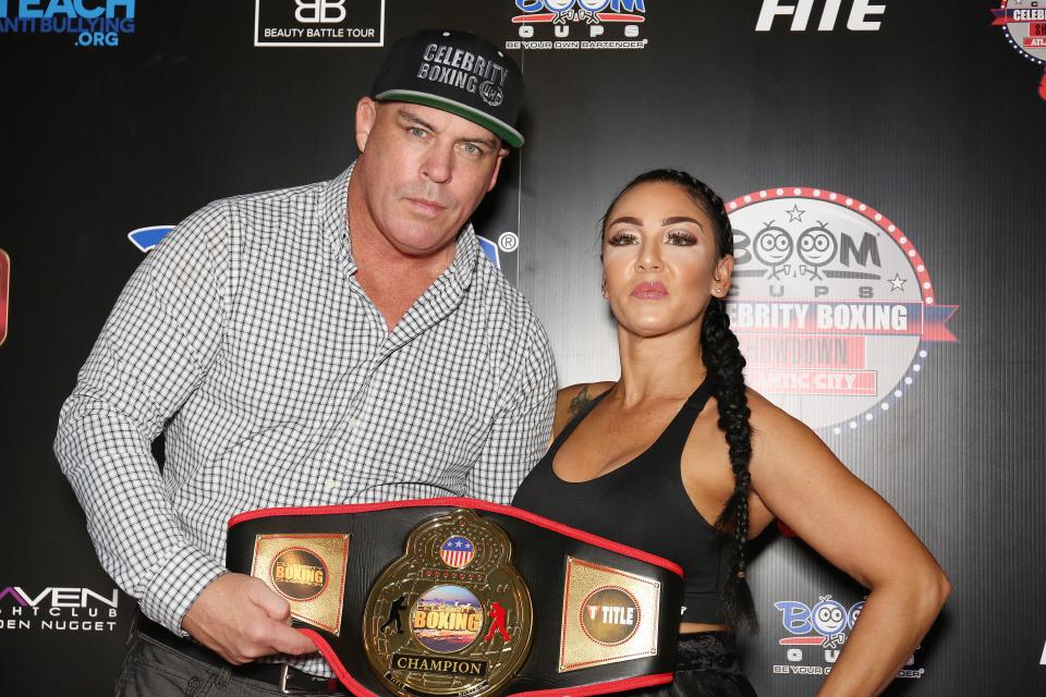 Damon Feldman and Natalie DiDonato with a celebrity boxing championship belt.