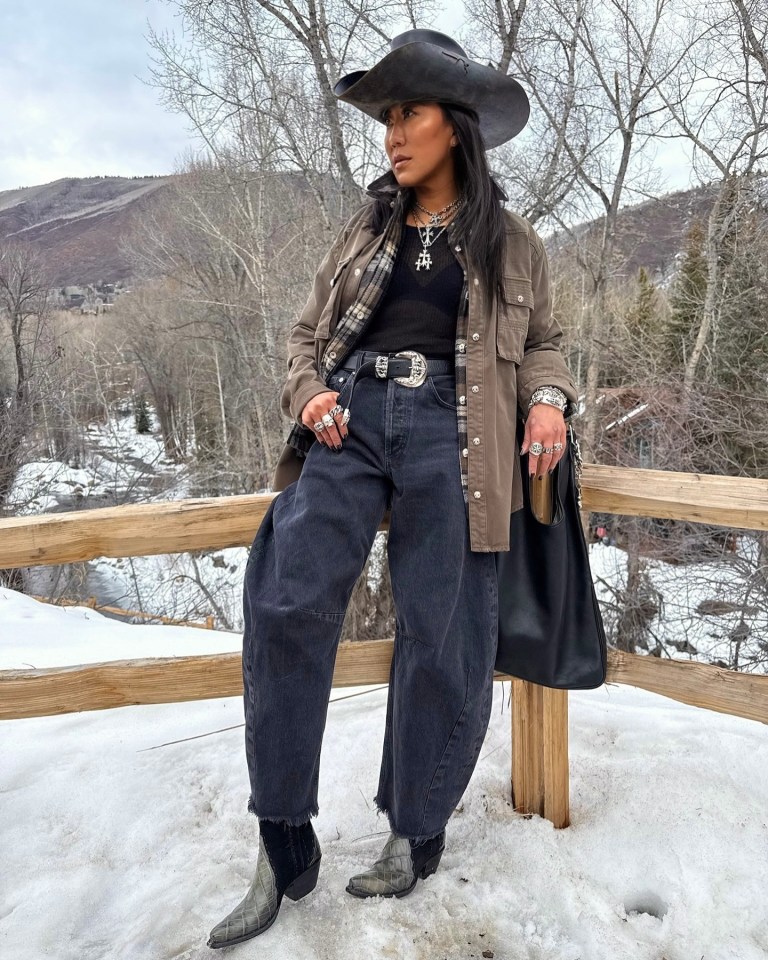 Lynn Ban in cowboy hat and outfit in snowy landscape.