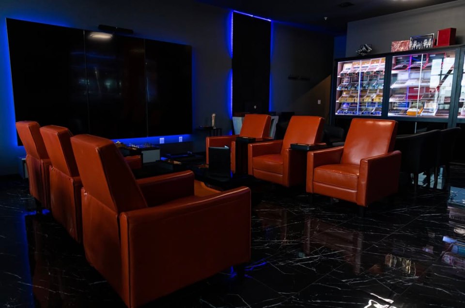 Private lounge with reclining chairs and a large screen.