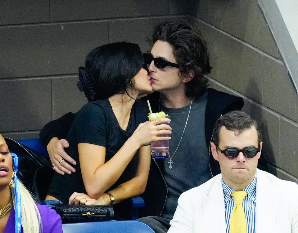 Kylie Jenner and Timothée Chalamet kissing at a tennis match.