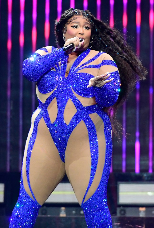 Lizzo performing in a blue sequined bodysuit.