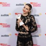 Bobbi Althoff holding an iHeartPodcast Award backstage.