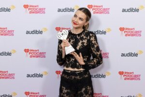 Bobbi Althoff holding an iHeartPodcast Award backstage.