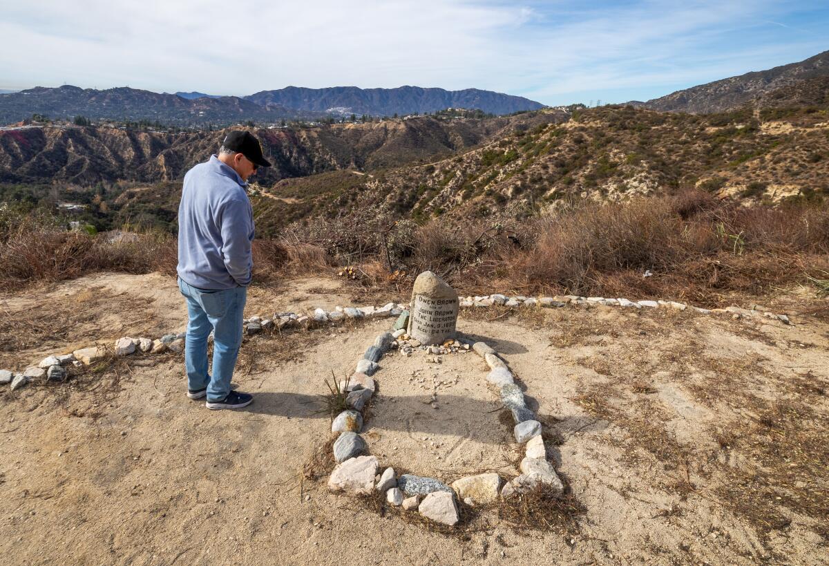 Pablo Miralles looks at the grave of Owen Brown.