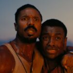 Michael b jordan and another man stand together in horror in sinners trailer