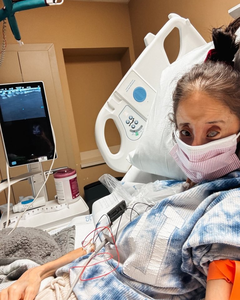 Lizzie Velásquez in a hospital bed, wearing a mask and connected to medical equipment.