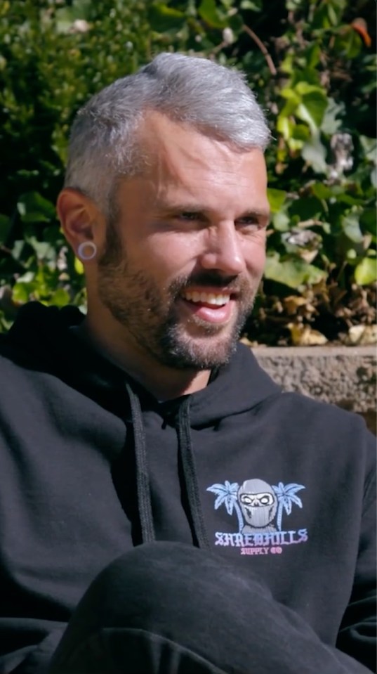 Close-up of Ryan Edwards, smiling and wearing a black hoodie.