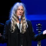 Patti Smith speaking at a microphone.