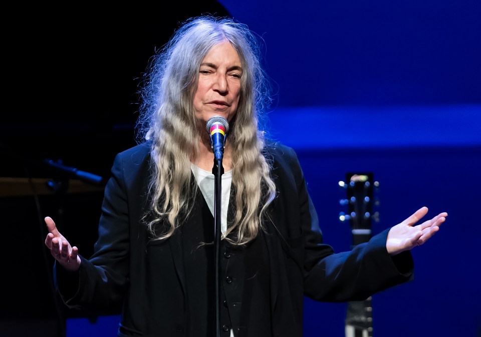 Patti Smith speaking at a microphone.