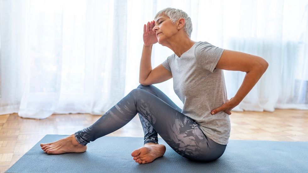 Woman with lower back pain on yoga mat