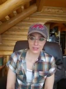 Adrienne Curry in a plaid shirt and baseball cap.