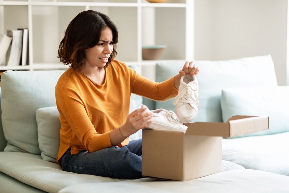 disappointed woman opening box of shoes