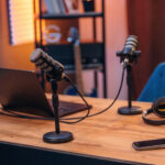 Microphones, headphones smartphone and laptop are on the table, room for podcasts