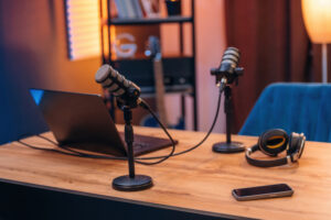 Microphones, headphones smartphone and laptop are on the table, room for podcasts