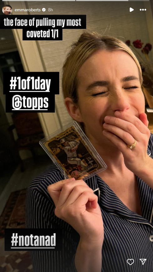 Emma Roberts holding a 1/1 Jackson Holliday card.