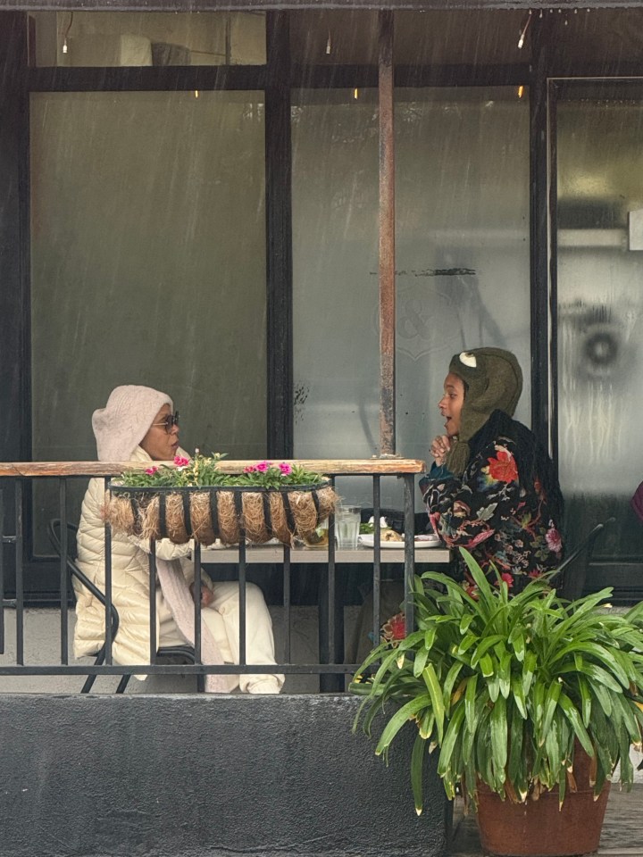 Jada Pinkett Smith and Willow Smith having lunch outdoors in the rain.