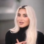 Kim Kardashian in a black turtleneck, speaking in a promotional image for The Kardashians season 6.