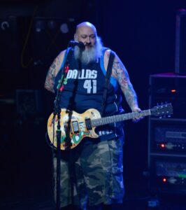 Chris Burney of Bowling for Soup performing on stage with a guitar.