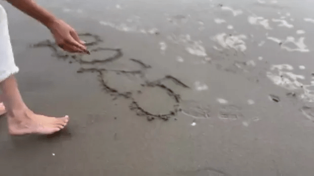 In a new Instagram post Meghan bends down to write '2025' in the sand