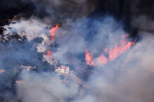 A house is threatened as the Palisades Fire grows in the mountains in the community of Topanga, California